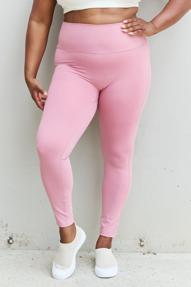 a woman in a white top and pink leggings