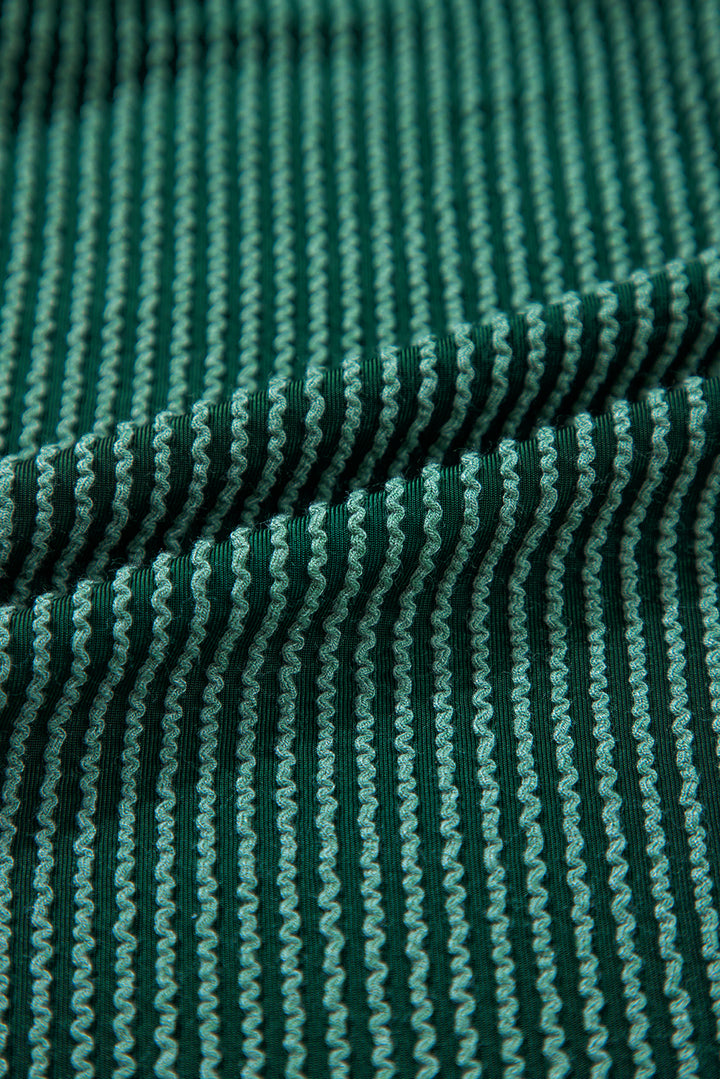 Close-up of green ribbed corded fabric from Evergreen JOLLY Set. Soft texture ideal for fall and holiday wear from Faith & Co. Boutique.
