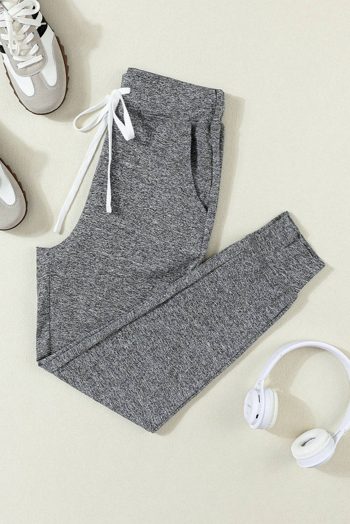 a pair of gray sweatpants and headphones on a white surface