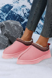a woman's feet wearing pink slippers and jeans