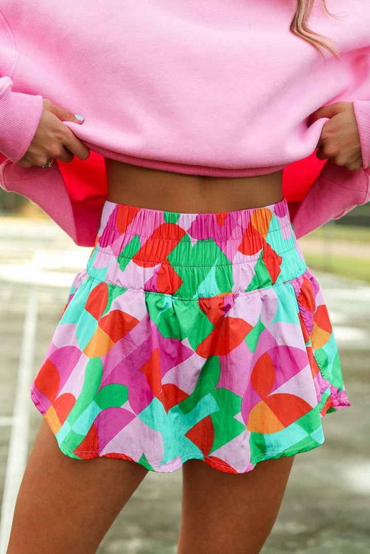 a woman in a pink sweater and colorful skirt