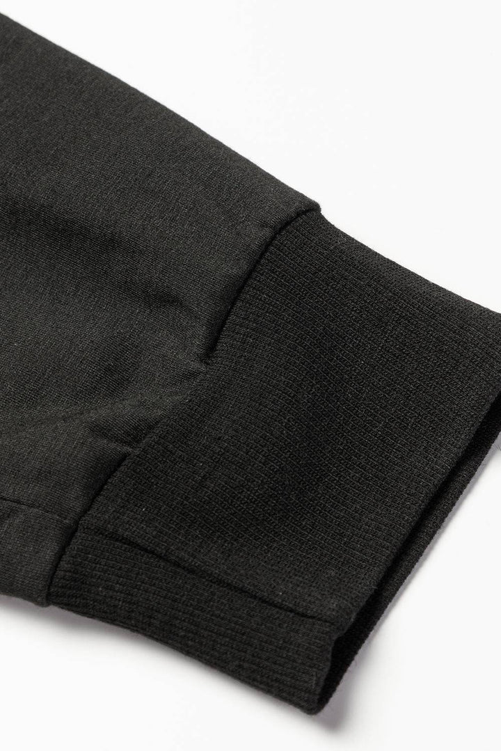 a close up of a black shirt on a white surface