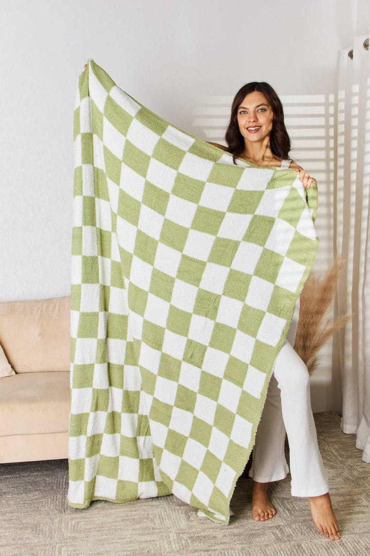 a woman holding a green and white checkered blanket