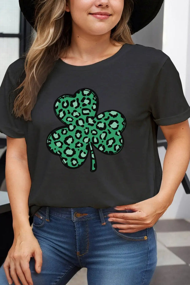a woman wearing a black hat and a black t - shirt with a green shamrock