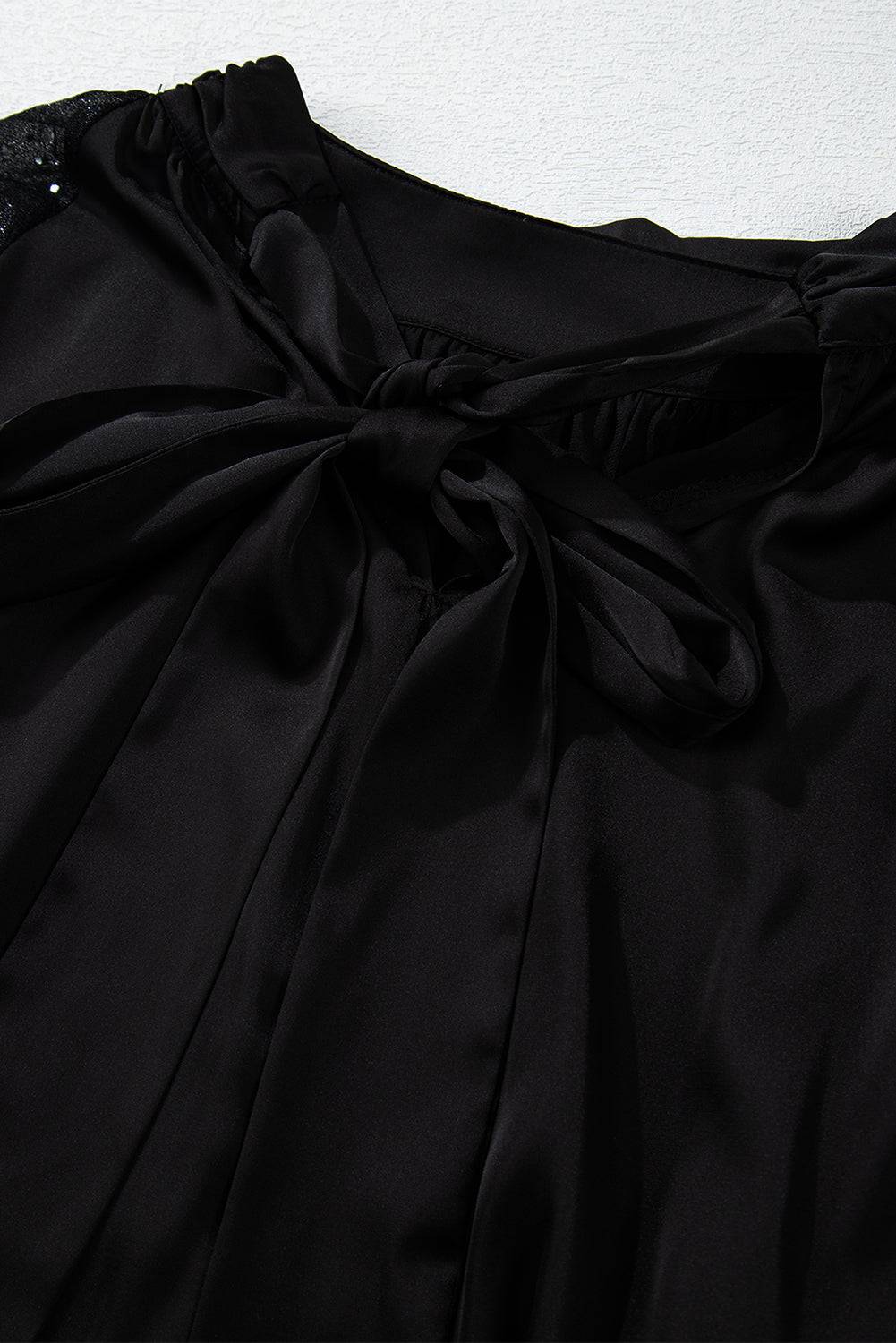 a close up of a black dress with a bow