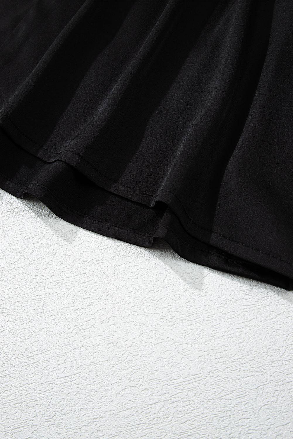 a close up of a black dress on a white surface