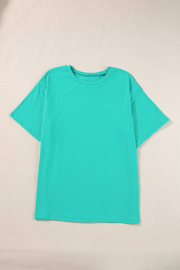 a green t - shirt hanging on a white wall