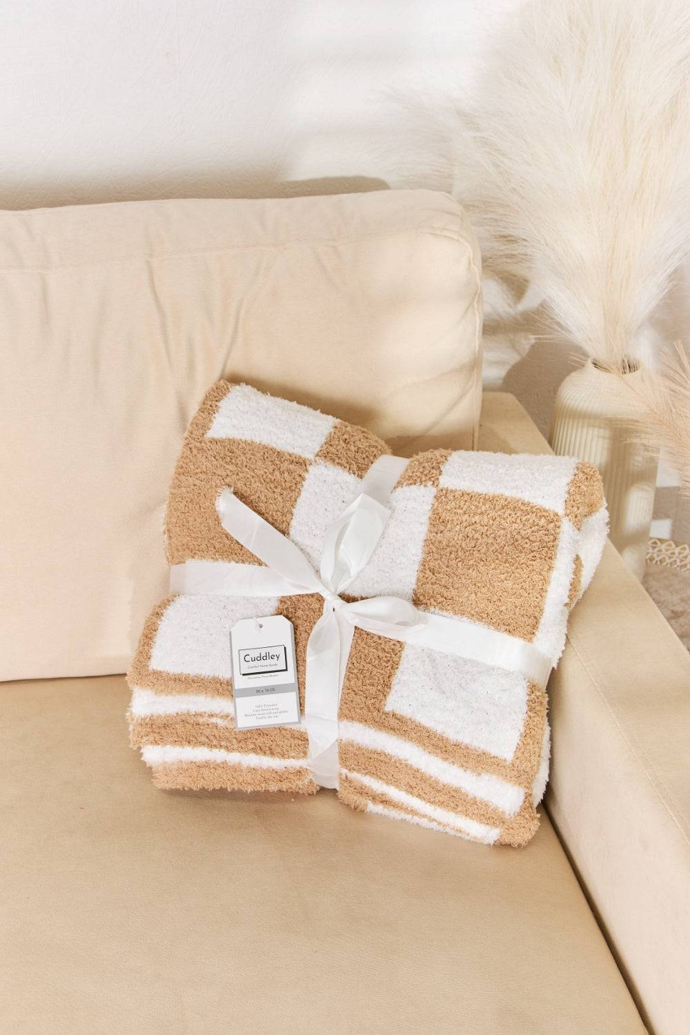 a white and brown blanket on a couch