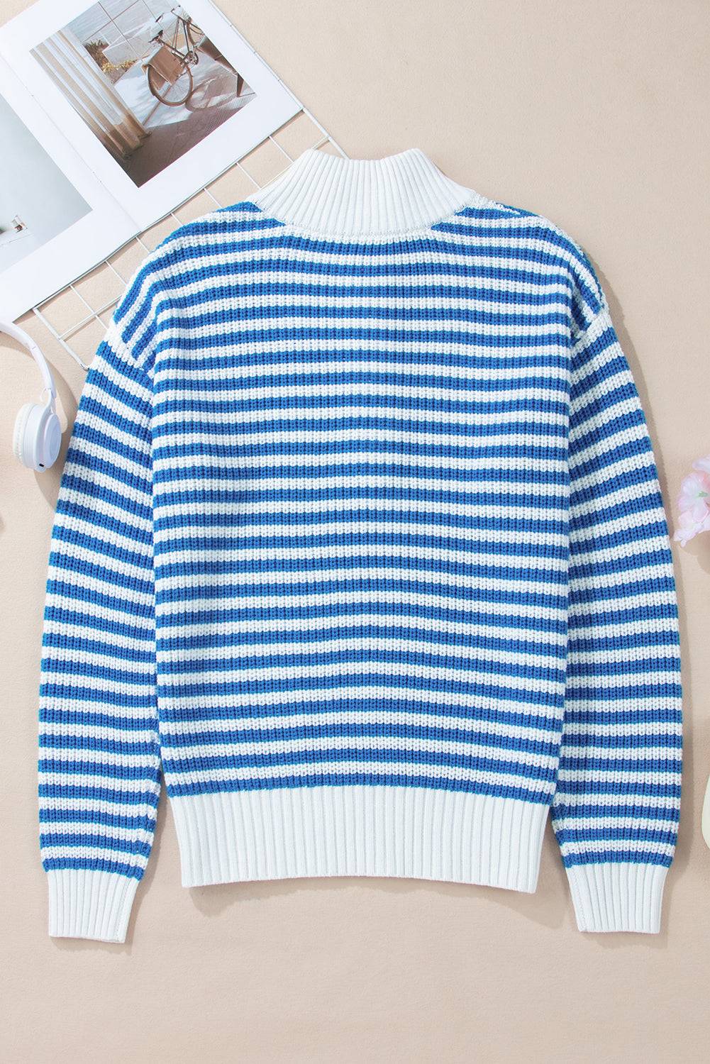 a blue and white sweater sitting on top of a table