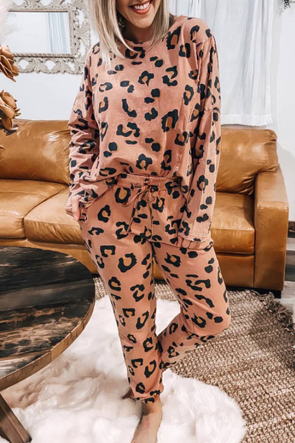 a woman wearing a pink leopard print pajama set