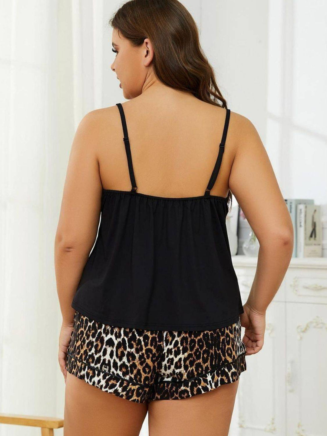 a woman in a black top and leopard print shorts