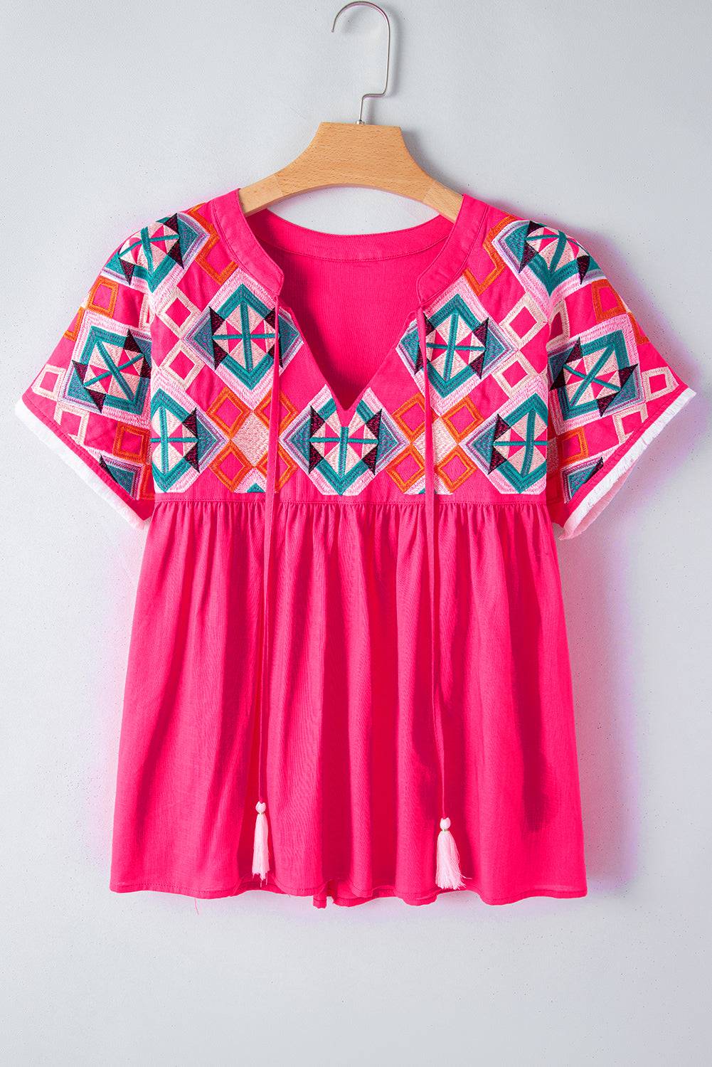 a pink top with a colorful pattern on it