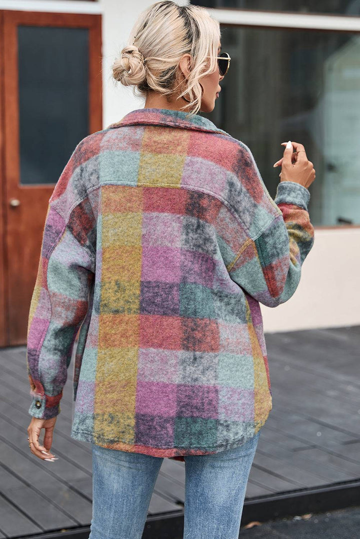 a woman in a multicolored jacket is walking down the street