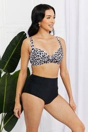 a woman in a leopard print bra top and black high waist shorts