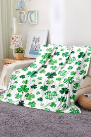 a green and white blanket sitting on top of a couch