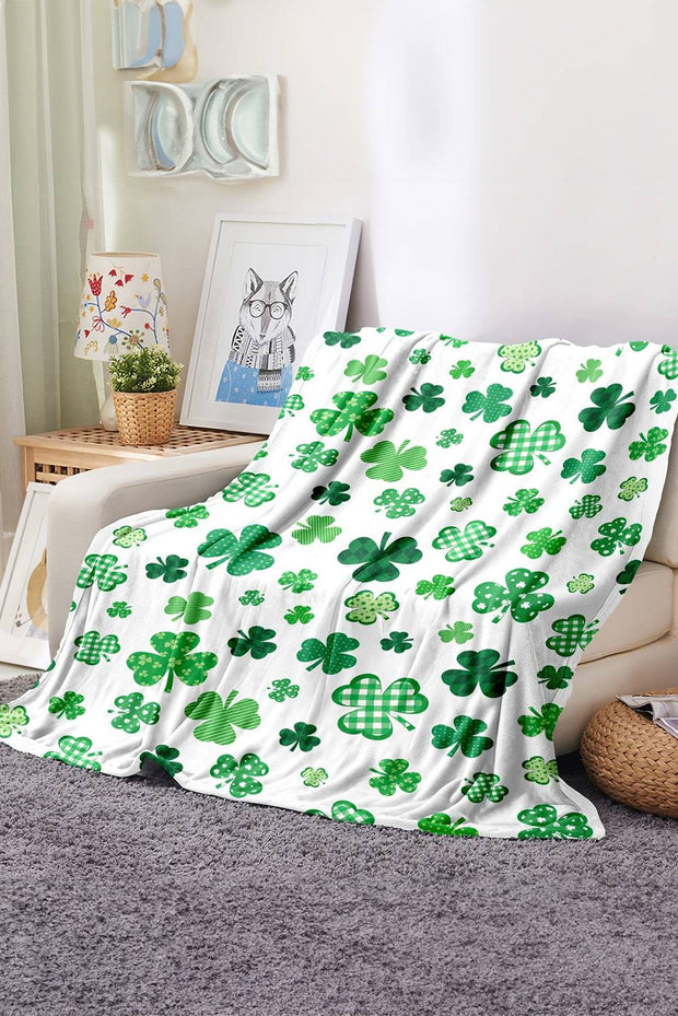 a green and white blanket sitting on top of a couch