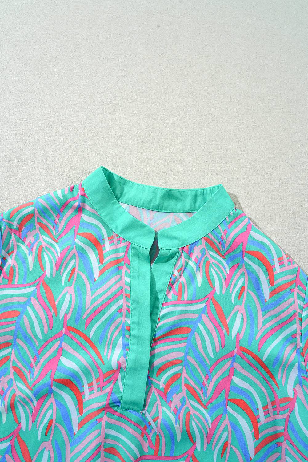 a blue shirt with a pink and blue design on it