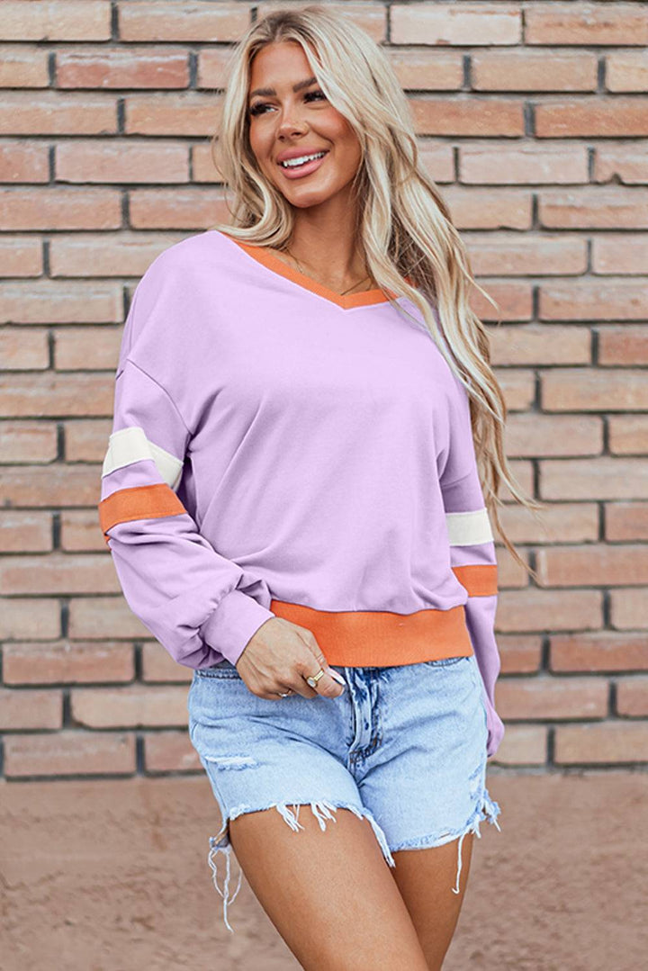 a woman standing in front of a brick wall