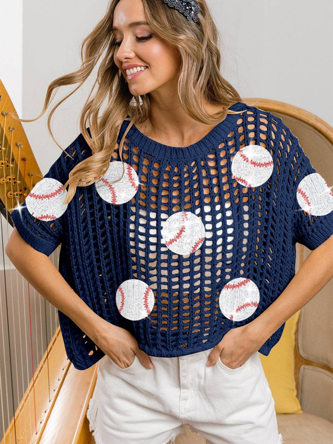 a woman wearing a blue sweater with baseballs on it