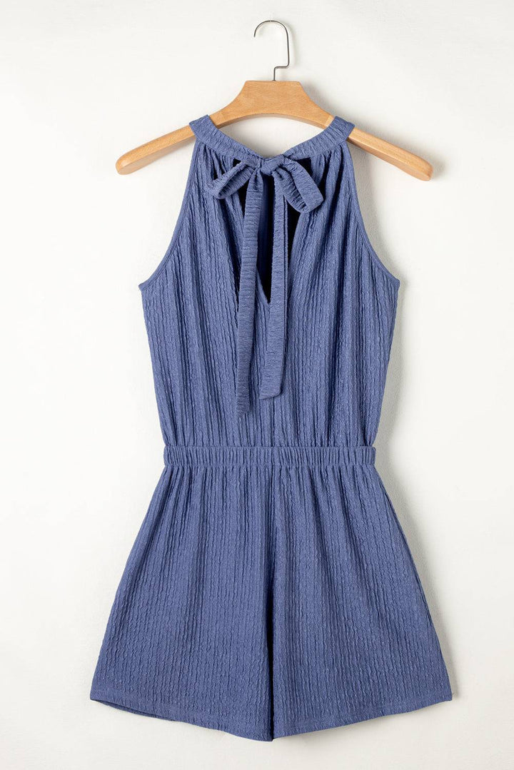 a blue romper romper with a bow at the neck