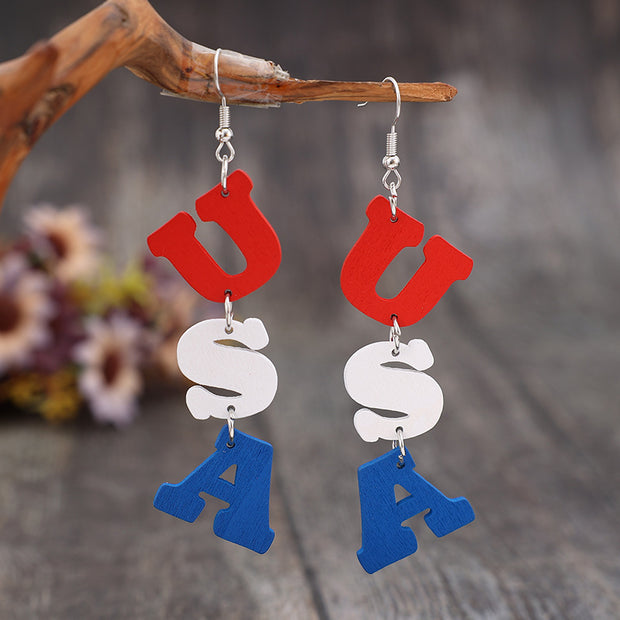 a pair of red, white and blue earrings hanging from a branch
