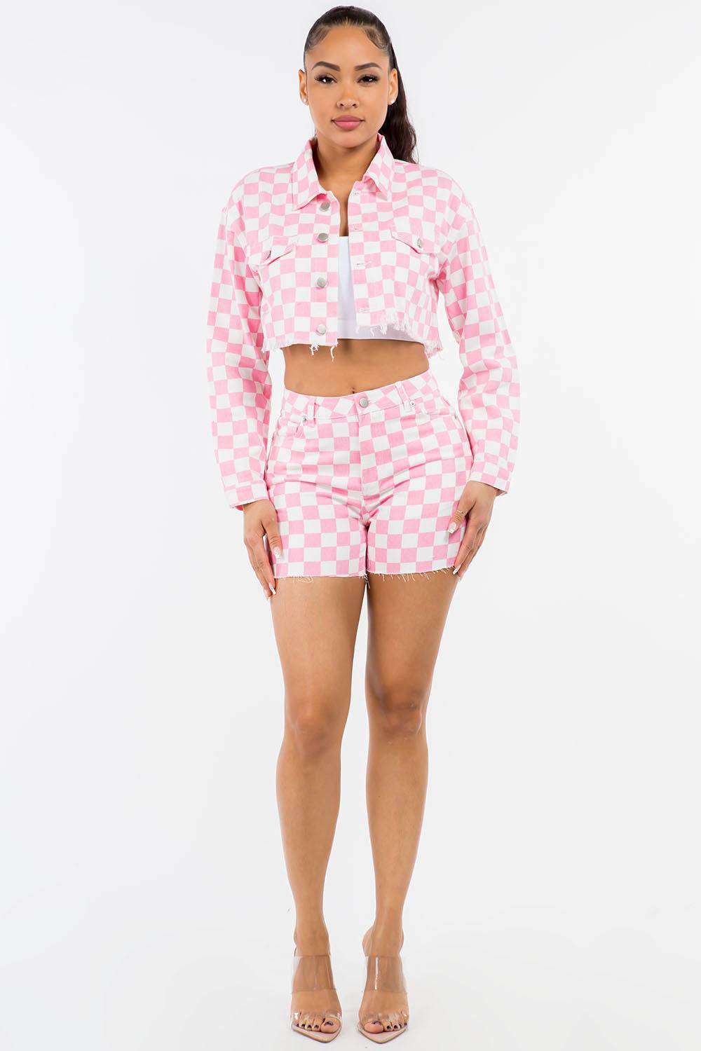 a woman in a pink and white checkered shirt and shorts