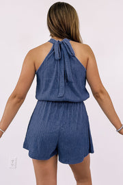 a woman wearing a blue romper and shorts