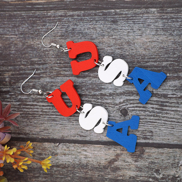 a pair of earrings with letters on them