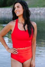 a woman in a red swimsuit standing in the water