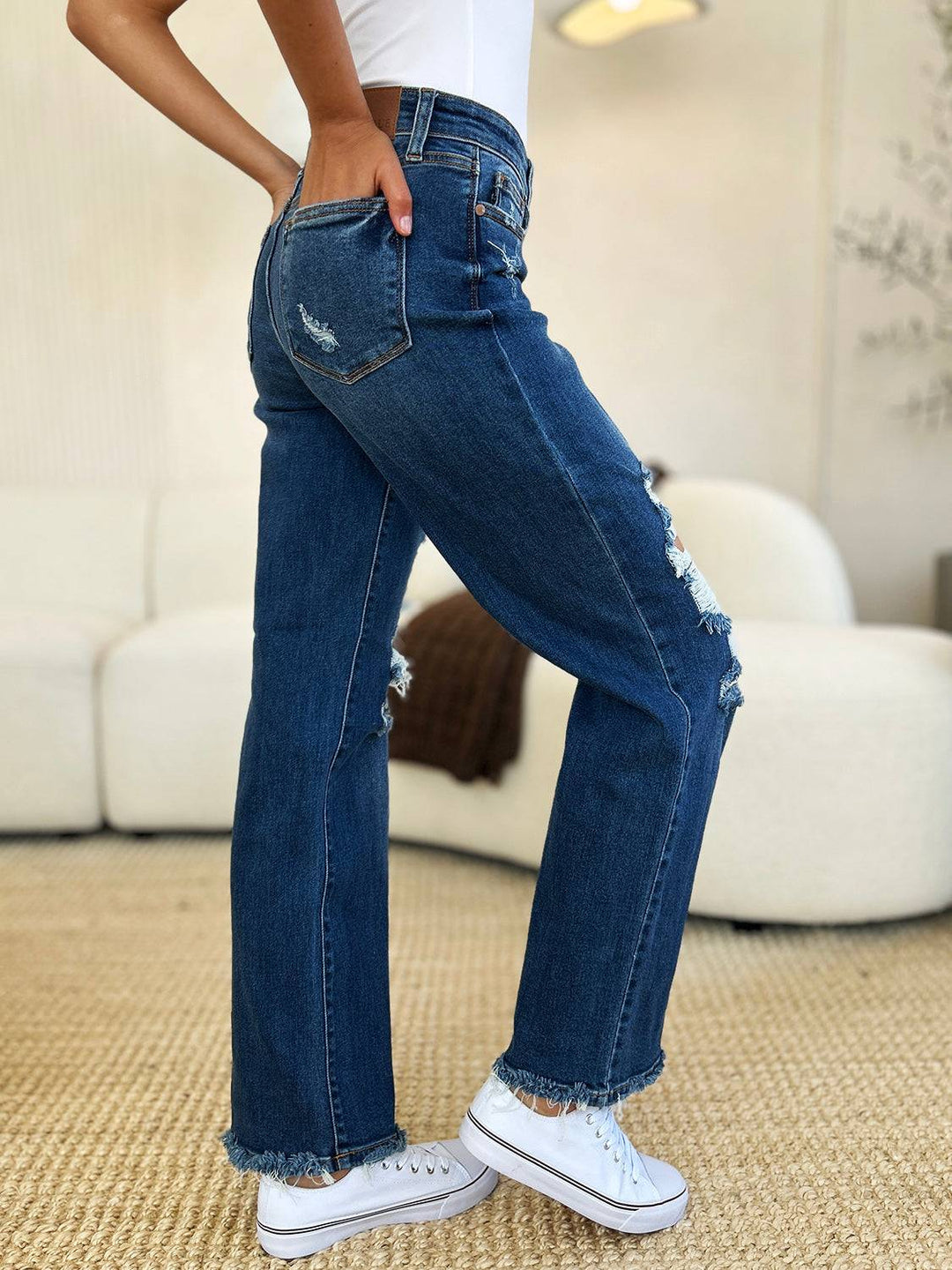 a woman in white shirt and jeans standing in a room