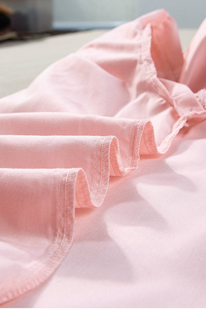 a close up of a pink shirt on a bed