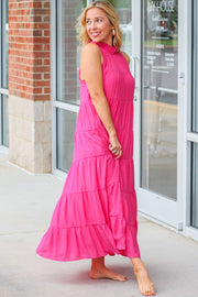 a woman in a pink dress standing outside of a building