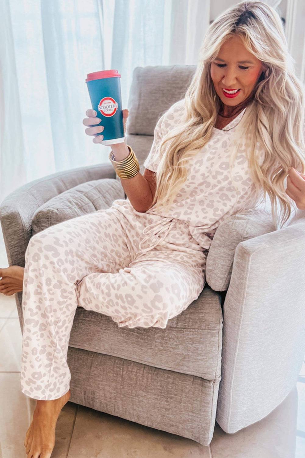 Model seated in a chair wearing Beige Cheetah V Neck Tee and Pants Lounge Set, showcasing cozy loungewear style from Faith & Co. Boutique.