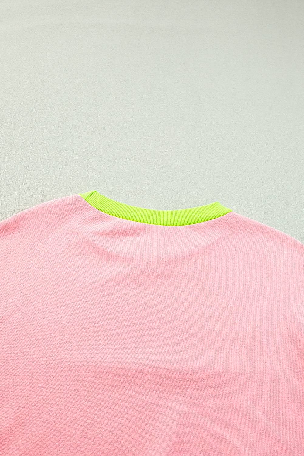 a pink shirt with a neon green collar