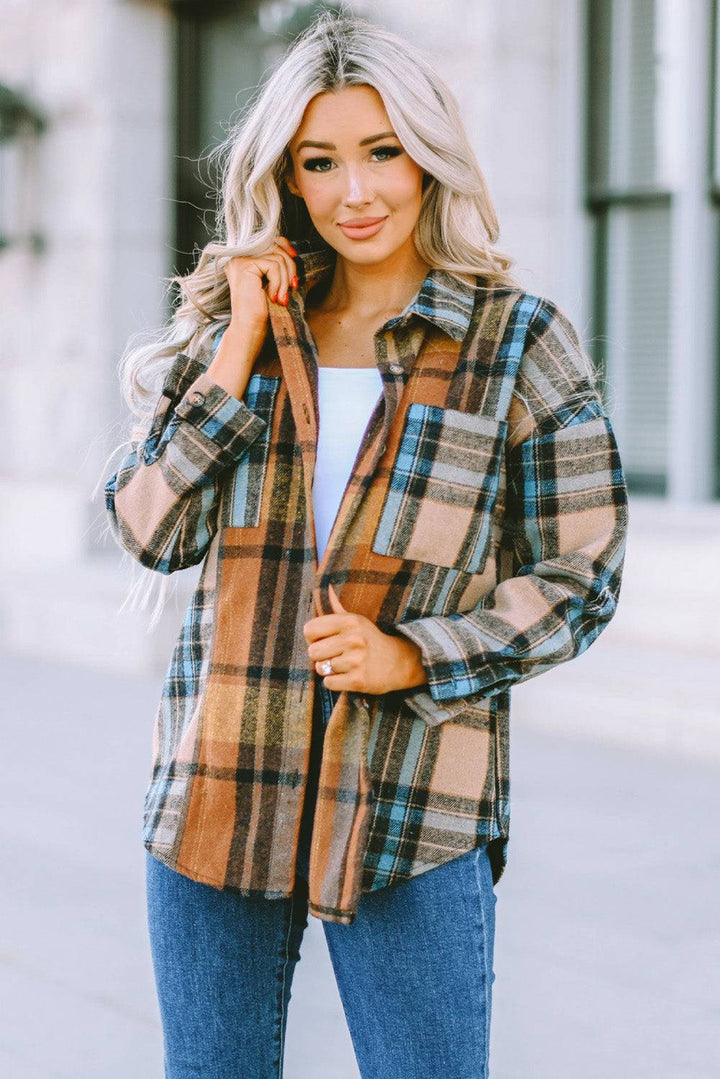 a woman wearing a plaid jacket and jeans