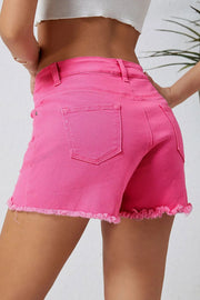 a woman wearing pink shorts and a white top