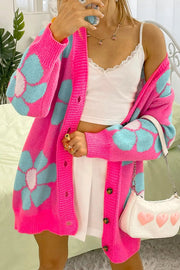 a woman taking a selfie while wearing a pink cardigan
