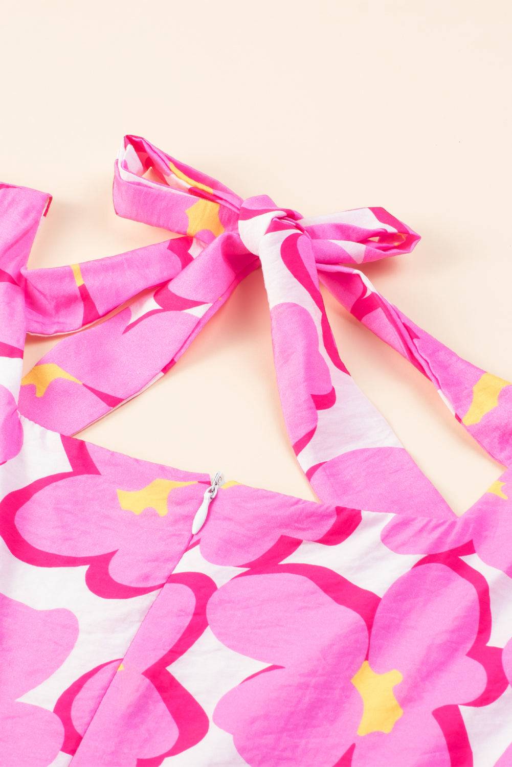 a close up of a pink and yellow flower print dress