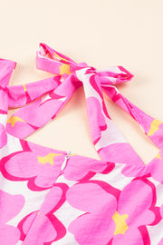 a close up of a pink and yellow flower print dress