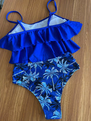 a blue and white swimsuit sitting on top of a wooden table