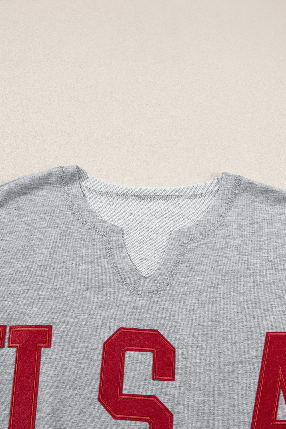 a gray t - shirt with red letters on it