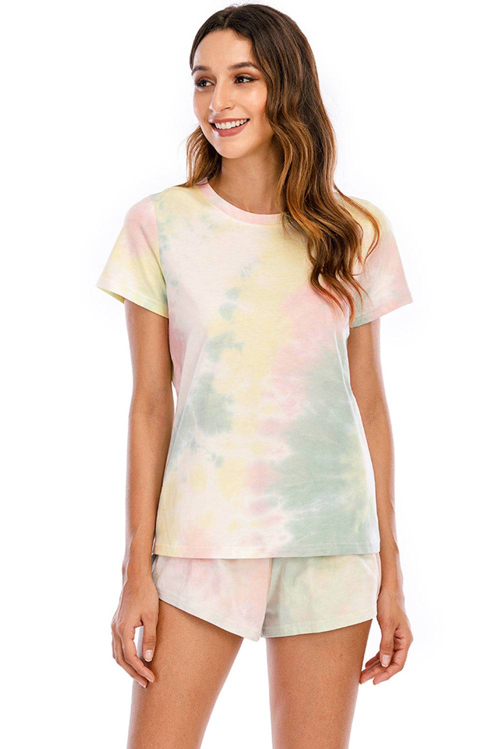 a woman wearing a tie dye shirt and shorts