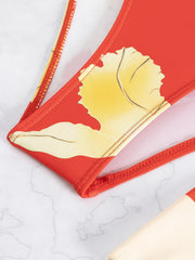 a red purse with a yellow leaf on it