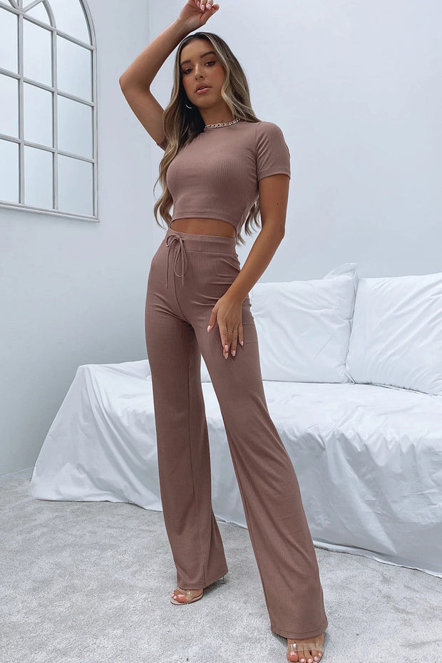 a woman in a crop top and wide legged pants