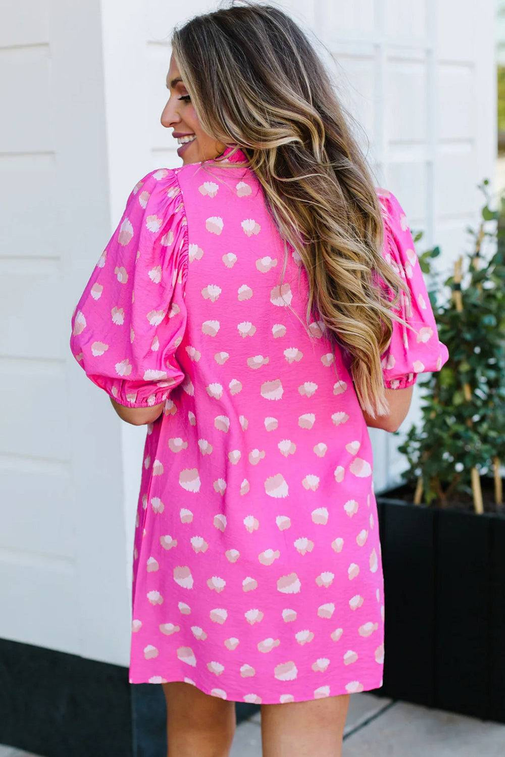 a woman wearing a pink polka dot dress