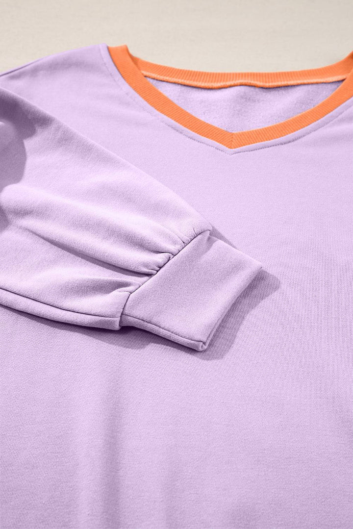 a close up of a purple shirt with an orange trim