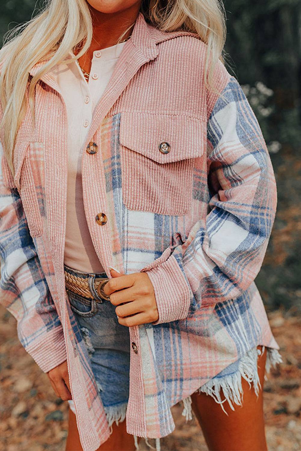 a woman wearing a pink plaid jacket and denim shorts