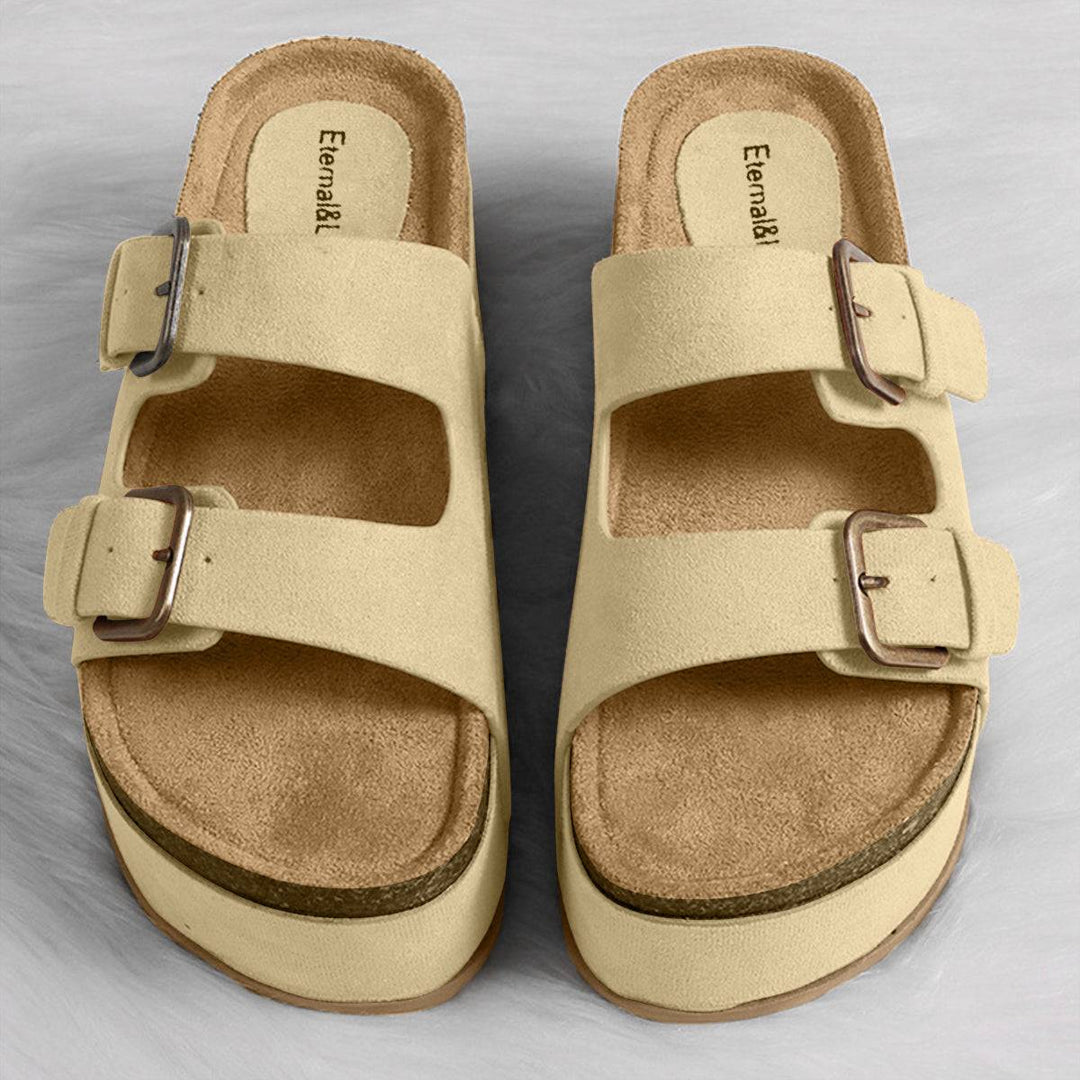 a pair of beige sandals with buckles on them
