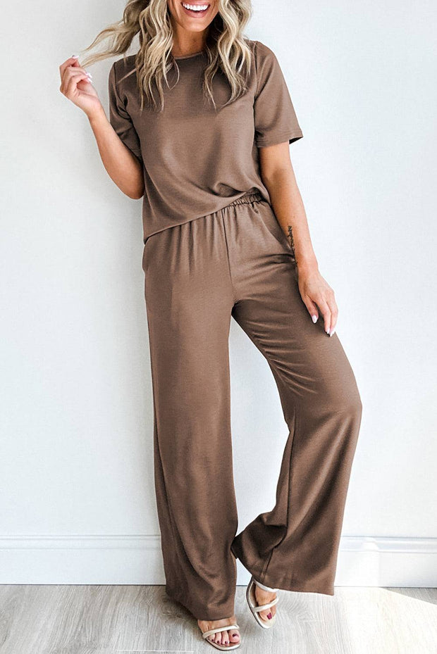 a woman in a brown jumpsuit posing for a picture