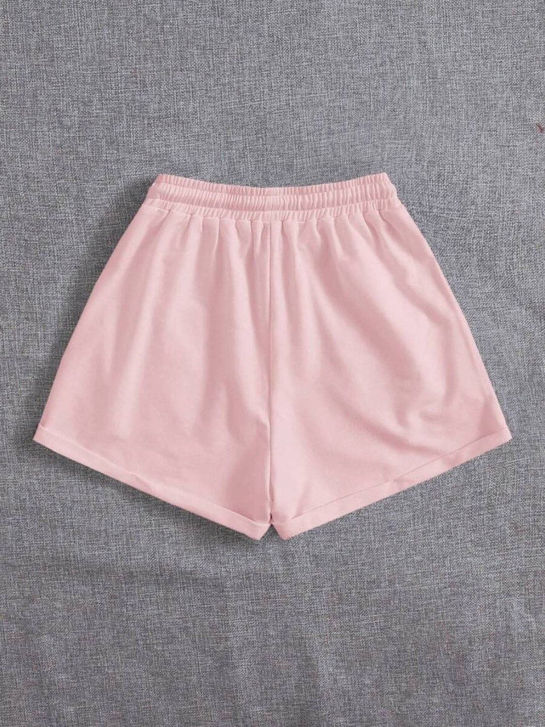 a pair of pink shorts sitting on top of a bed